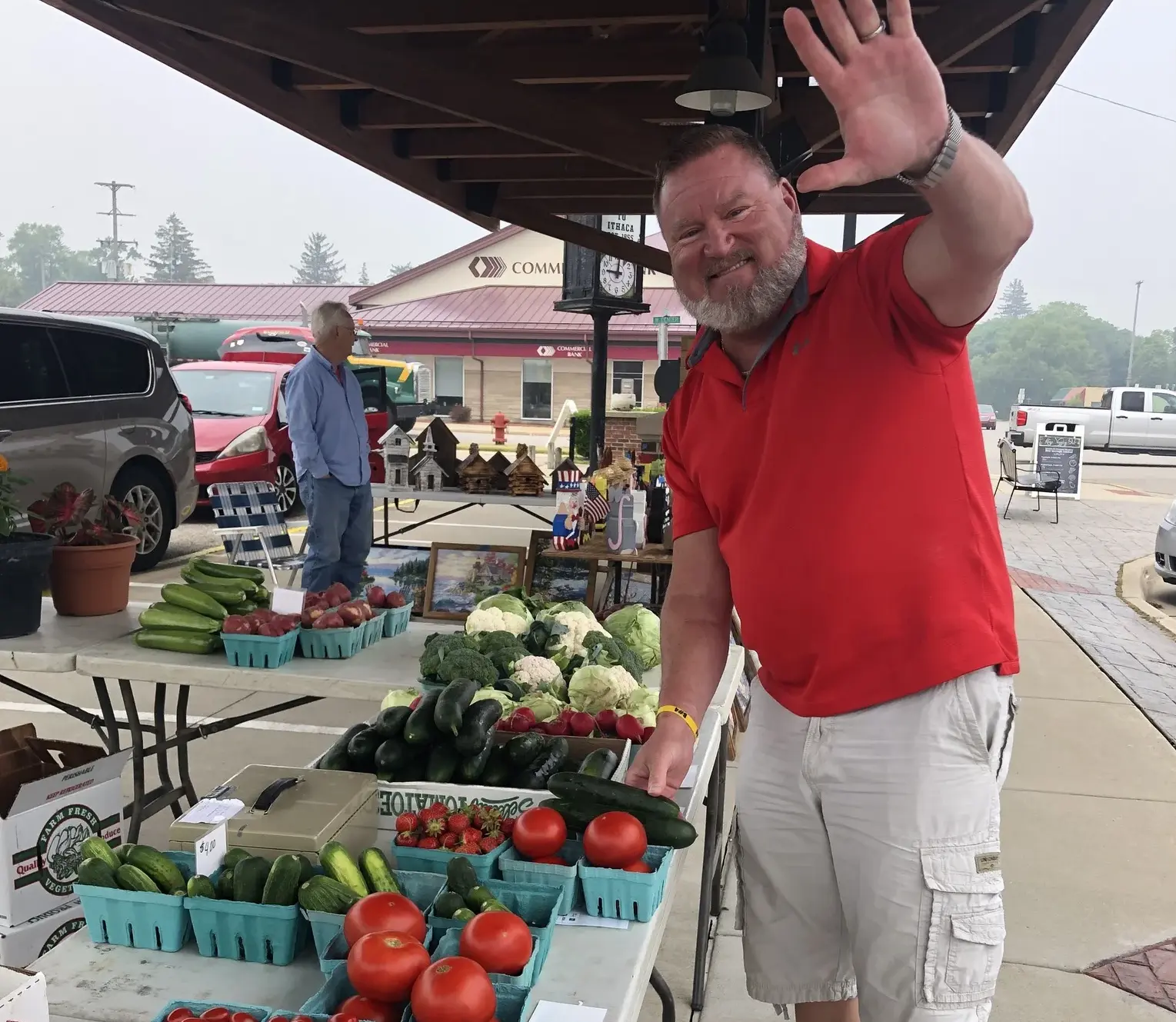 Man waving at the Ithaca farmers market